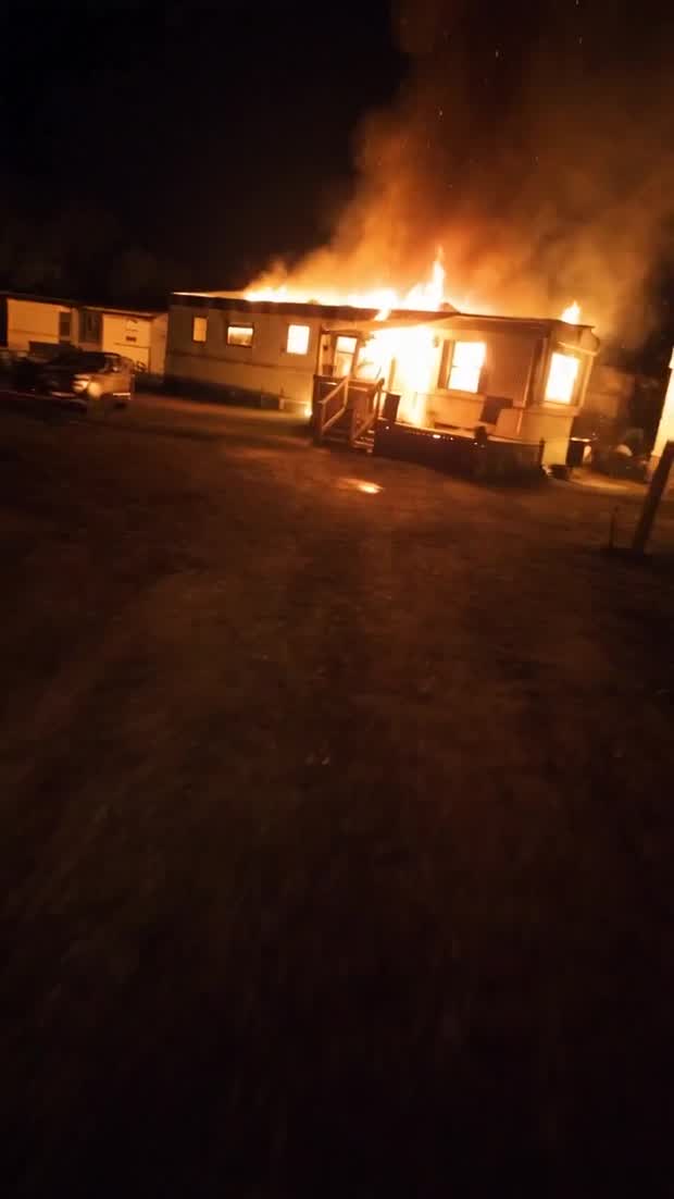Double Wide Desires: a trailer burning at night in an empty lot
